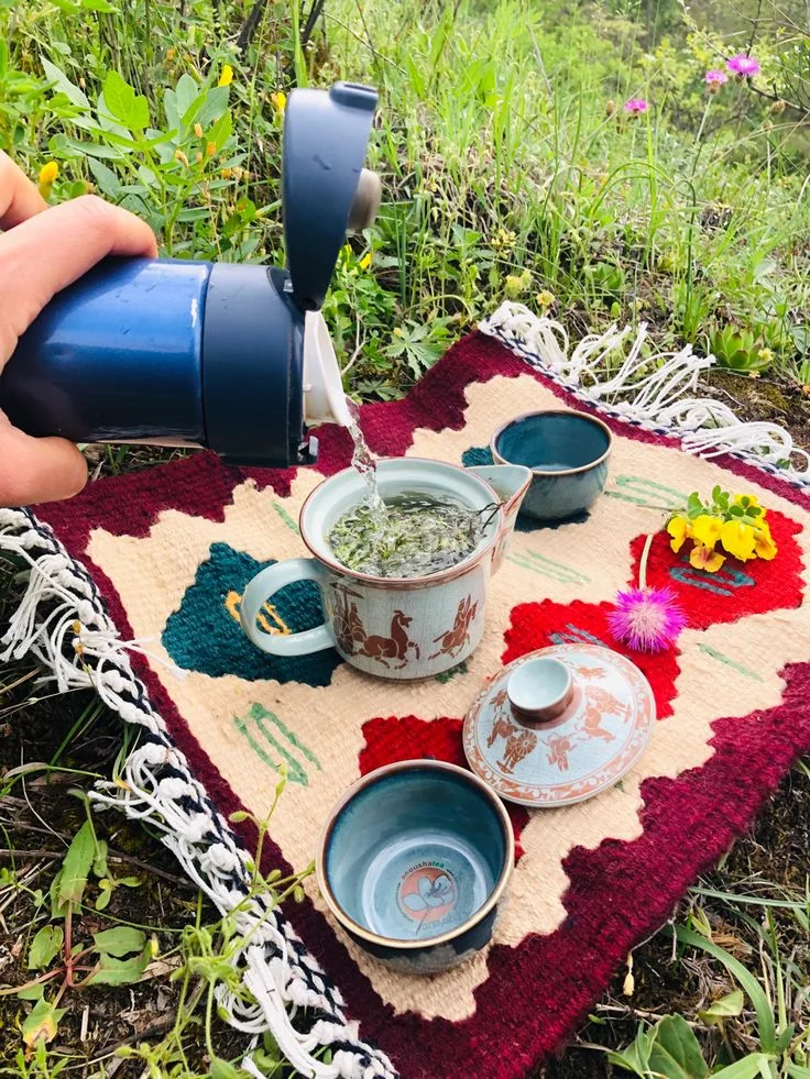 Persona disfrutando té al aire libre en contacto con la naturaleza