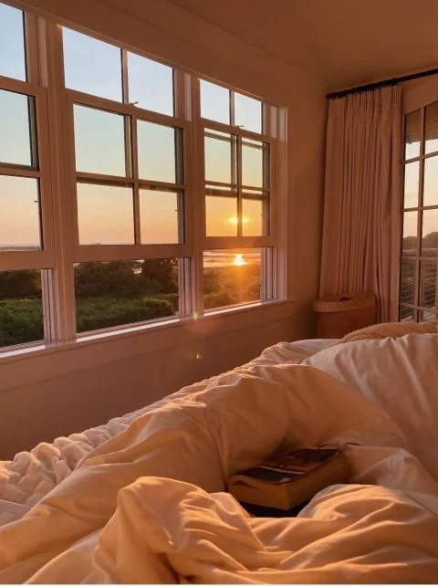Dormitorio acogedor con luz cálida al atardecer y cama junto a ventana