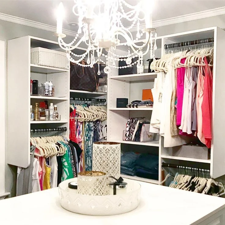 Closet blanco organizado con perchas uniformes y cajas acrílicas